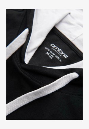Haut à capuche noir avec des cordons blancs et une doublure intérieure, affichant une étiquette indiquant "ombre cotton lines 100% pur coton M|48".