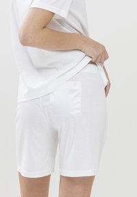 Witte katoenen shorts met een satijnen zak. Elastische tailleband, knielang ontwerp en een gladde textuur. Eenvoudige en minimalistische stijl.