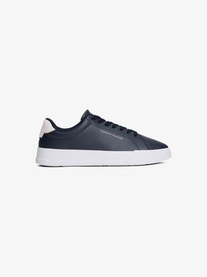 Tenis masculinos azul-marinho feitos de couro liso, com sola de borracha branca, ponta arredondada e uma marcação discreta na lateral e na parte de trás.