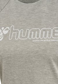 Grijze katoenen T-shirt met een wit logo met het woord "humme" en de zin "VERANDER DE WERELD DOOR", ronde halslijn en korte mouwen.