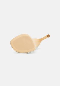 Une seule chaussure à talon haut beige couchée sur le côté, montrant la semelle texturée et le talon fin sur fond blanc.