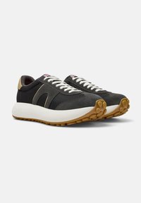 Sneaker in rete e suede neri con lacci bianchi e un'accenno beige. Suola in gomma con motivi di battistrada circolari per una migliore aderenza.