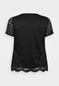 Haut en dentelle noire à manches courtes, avec un motif floral, un ourlet à volants et un tissu texturé pour un look superposé.