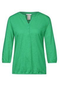 Grön topp med trekvartsärmar och V-ringning, med knapplist. Mjuk, lätt tyg som har en lös passform, med volang ärmslut.