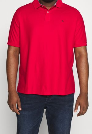 Camiseta polo roja de manga corta, con cuello y tapeta de botones. Confeccionada con tejido liso, presenta un pequeño logo en el pecho.