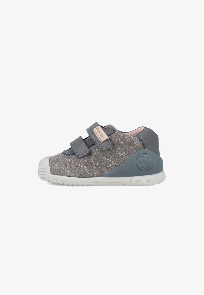 Zapatilla de ante gris con dos correas de velcro ajustables, parte superior texturizada, suela de goma y puntera reforzada; logo de la marca en el talón.