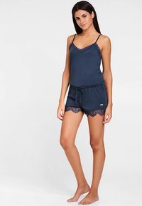 Marinblå sovset med ärmlös topp med spetskant och matchande shorts med spetsdetaljer. Mjukt tyg med resår i midjan.