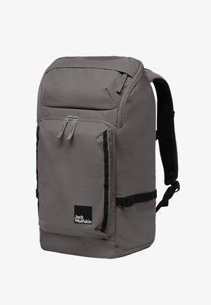 Sac à dos gris avec plusieurs compartiments, texture lisse, bretelles réglables et un logo noir proéminent à l'avant.