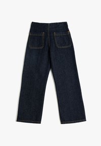 Pantalones de mezclilla azul oscuro con corte recto. Cuenta con dos bolsillos traseros y costuras en color naranja. Tejido duradero con una textura suave.