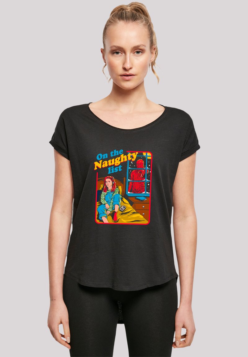 Black short-sleeve T-shirt featuring a colorful graphic print of a girl sitting on a bed with the text "On the Naughty List" above.