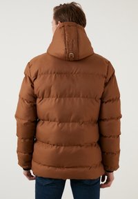 Brun puffjacka med huva, vadderad design med horisontella sömmar och elastiska ärmmuddar, tillverkad av ett slätt, vattenavvisande tyg.