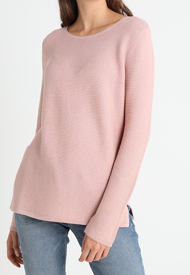 Light pink ribbed sweater with a round neckline and long sleeves, featuring side slits, paired with blue jeans.