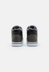 Zapatillas altas con parte superior de cuero, laterales en gris oscuro, acentos en negro, forro gris suave y suela de goma blanca.