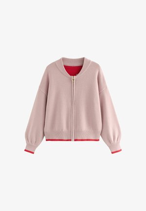 Sweter z polaru w jasnoróżowym kolorze z złotym zamkiem, żeberkowanymi mankietami i dołem. Wnętrze wykończone jasnoczerwonym materiałem. Luźny krój i okrągły dekolt.