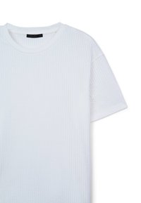 Maglietta bianca a maniche corte con un motivo a coste testurizzato, scollo rotondo e un'etichetta che mostra il marchio "CALLIOPE" nella taglia L.