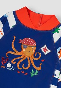 Temno modra kopalna obleka z rdečimi dodatki, ki vsebuje vezenega oranžnega hobotnico, piratsko zastavo in podvodne motive. Gladek, raztegljiv material.