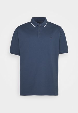 Polo bleu marine à manches courtes avec bordure blanche au col, trois boutons et petit logo Tommy Hilfiger sur la poitrine gauche.