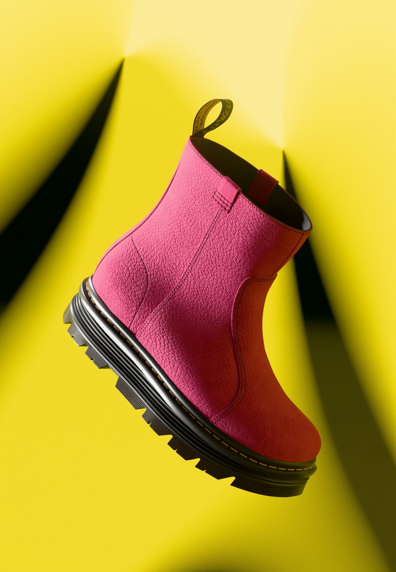 Bottines magenta avec une tige texturée, une languette et une semelle noire épaisse arborant un motif de semelle robuste. Présentées sur un fond jaune.