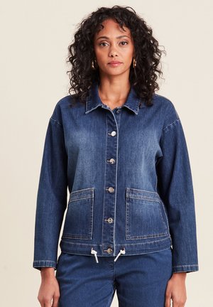 Veste en denim bleu foncé avec une fermeture à boutons, deux grandes poches avant, un ourlet ajustable à cordon de serrage et un col classique. Texture douce.