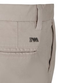 Beige katoenen broeken met een slank ontwerp, voorzien van een klein metallic logo, zichtbare stiksels en een zijzak aan de rechterkant.