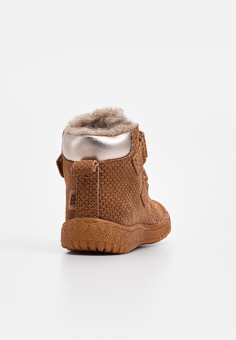 Braune Stiefeletten aus strukturiertem Material, mit einem metallisch silbernen Absatz, weichem Futter aus Fell an der Oberseite, rutschfester Gummisohle und Schlaufe.