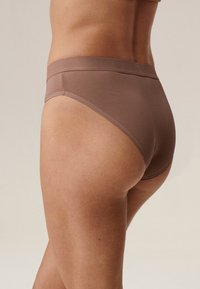 Brązowe bawełniane majtki z szerokim paskiem, gładką teksturą i klasycznym krojem, z minimalnymi przeszyciami i wysokim krojem na biodrach.