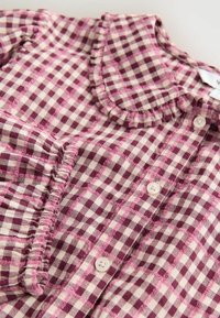 Roze en crème geblokte katoenen blouse met gerimpelde halslijn, knoopsluiting en contrasterende stiksel-details.
