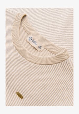 Pull en maille côtelée beige avec encolure arrondie, étiquette de marque visible "Ombre Heritage", taille moyenne, et petite étiquette métallique de la marque sur le tissu.