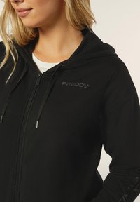 Felpa nera con zip realizzata in tessuto morbido. Presenta un cappuccio, una zip argentata e il logo ricamato "FREDDY" sul petto.