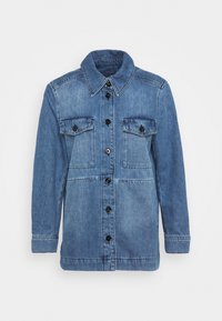 Chaqueta de denim en azul claro, con cierre de botones en la parte delantera, dos bolsillos en el pecho y un cuello clásico. Tejido texturizado con un corte recto.