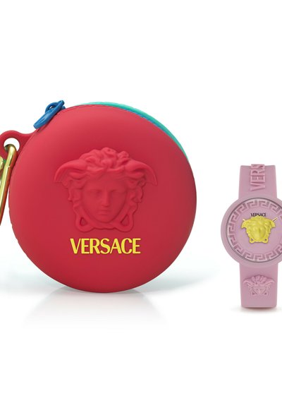 Červená kulatá taška Versace s embosovanou hlavou Medusy a žlutým logem, vedle růžových hodinek se žlutým emblémem Medusy na ciferníku a pásku.