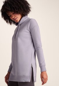 Light purple pullover with a cowl neck, long sleeves, side zip accents, and a relaxed fit. Ribbed cuffs and hem complete the design.