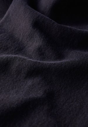 Tissu bleu marine foncé avec un tissage doux et texturé, montrant des rides et des plis subtils. Le matériau semble durable et flexible.