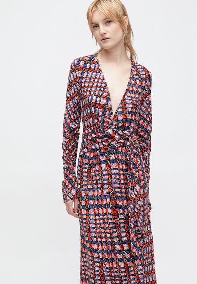 Vestido cruzado feito de tecido estampado colorido em vermelho, azul e preto. Apresenta mangas longas e uma cintura definida com um cinto amarrado.