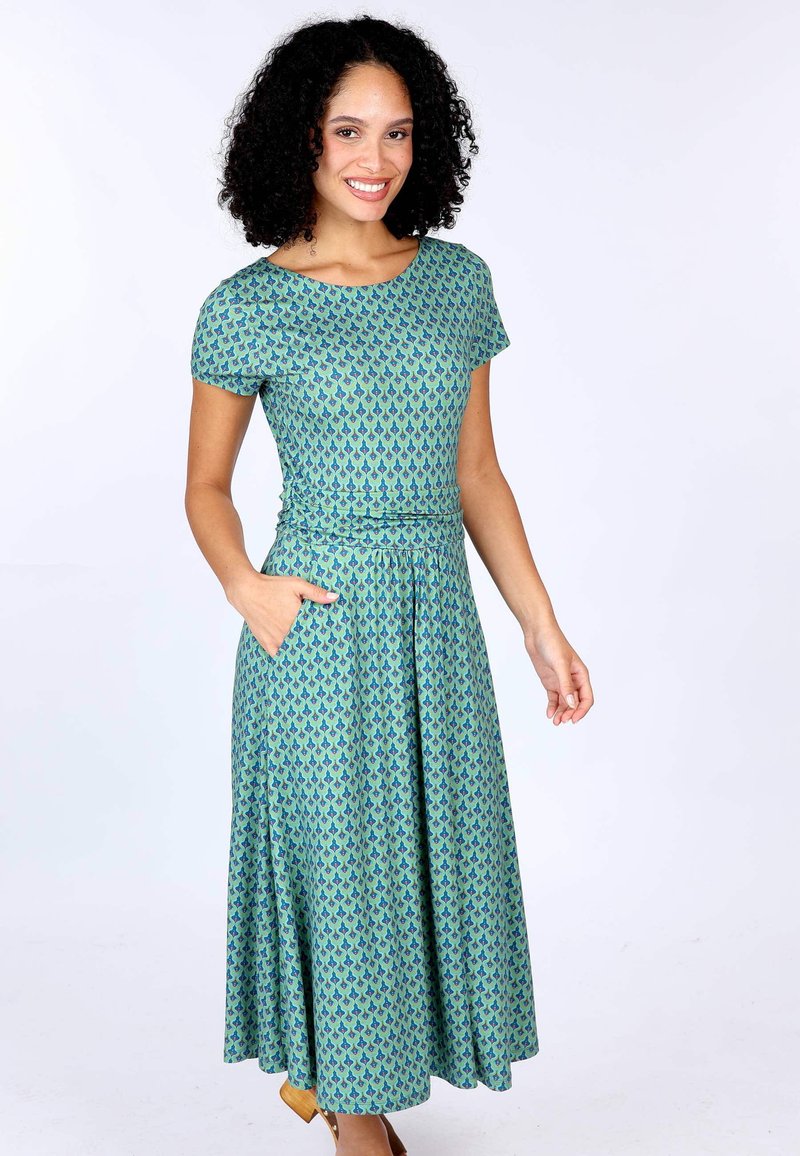 Kurzärmliges, knielanges Kleid in Grün mit einem blauen Muster. Verfügt über ein tailliertes Oberteil und einen schwingenden Rock, mit seitlichen Taschen. Glatte Stofftextur.