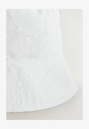 Valge ämbri müts, mis on valmistatud kerge kangast, millel on lilleline tikand ja pehme, tekstureeritud pind. Äär on õrnalt kõverdatud.