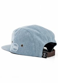 Cappellino in denim blu con visiera piatta, caratterizzato da un logo circolare e dettagli cuciti. Include occhielli per ventilazione e una cinturino regolabile marrone.