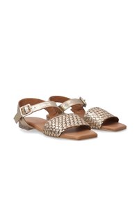 Metalen gouden sandalen met geweven leren banden en een platte zool. Gespsluiting bij de enkel en een open teen ontwerp. Patronen op de bovenste band.