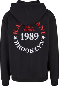 Sudadera negra con bolsillo frontal, con un diseño impreso en forma de círculo en rojo y blanco que dice "KAYANI EST. SINCE 1989 BROOKLYN". Tejido suave, corte casual.