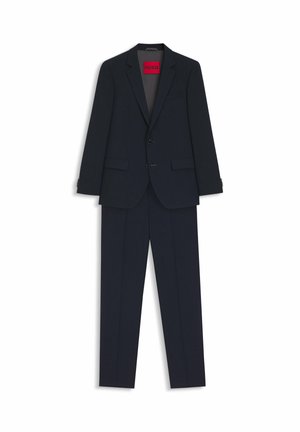 Marinblå kostym i slät tyg, med tvåknäppt kavaj, slag med hack och byxor med platt front. Röd "HUGO"-etikett på insidan av kavajen.