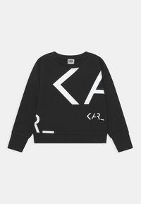 Černá mikina s dlouhými rukávy, kulatým výstřihem a bílou geometrickou grafikou. Má zkrácený střih a jemný materiál.