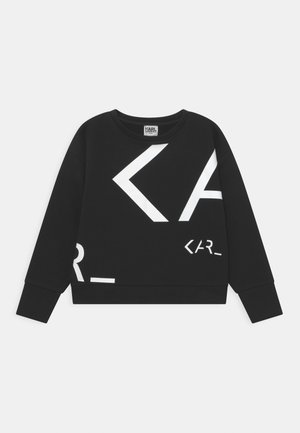 Sudadera negra de manga larga, con cuello redondo y gráficos geométricos blancos. Presenta un diseño corto y un material suave.