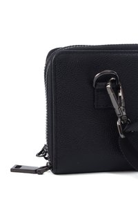 Black leather zippered bag with textured surface, featuring a metal clasp and adjustable strap for versatility.