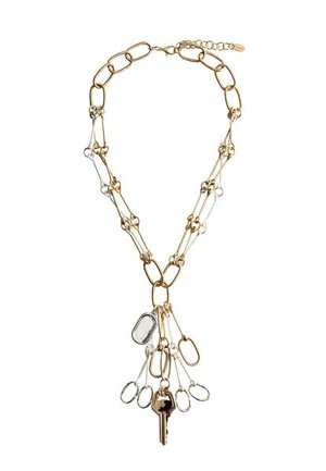 Guld- og sølvkæde med sammenlåste led, der har flere små løkker og et enkelt guldnøglevedhæng, der hænger i midten.