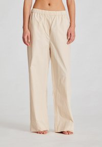 Pantaloni bej, cu croială largă și talie elastică. Realizați dintr-un material ușor, având o textură netedă și fără buzunare sau modele vizibile.