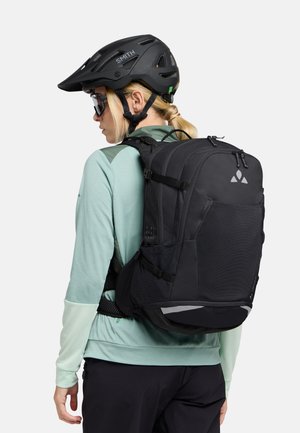 Zaino nero con tasche laterali in rete e un accento riflettente. Realizzato in materiale resistente, presenta spallacci regolabili per una vestibilità e comfort ottimali.