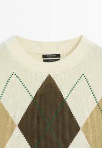 Pull en tricot crème avec col côtelé, présentant un motif losanges marron, beige et blanc avec des accents de coutures vertes, tissu en coton.