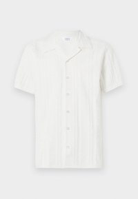 Camisa blanca de manga corta con un patrón texturizado, cierre de botones en la parte delantera y un bolsillo único en el lado izquierdo. Fabricada con tela ligera.
