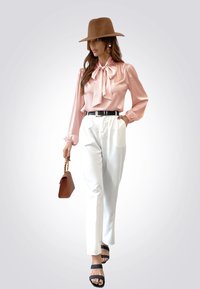 Blusa de satén rosa claro con un collar de lazo, pantalones blancos de cintura alta, cinturón negro, sombrero marrón y bolso marrón. Sandalias negras con tiras.
