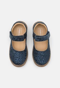 Granatowe buty typu Mary Jane z perforowanym wierzchem, rzepem i beżową wkładką. Mają teksturowaną podeszwę. Widoczne szczegóły rozmiaru i marki.